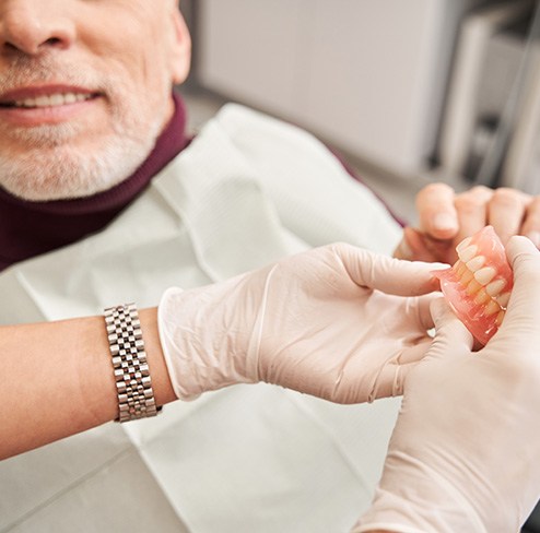 A dentist showing dentures to her patient