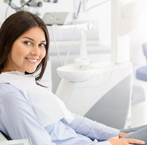 Woman sitting in dental chair and smiling